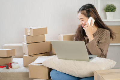 Young woman using mobile phone in box