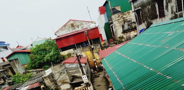 High angle view of houses amidst buildings against sky