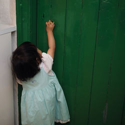 Full length of child on door