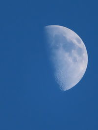 Low angle view of moon against blue sky