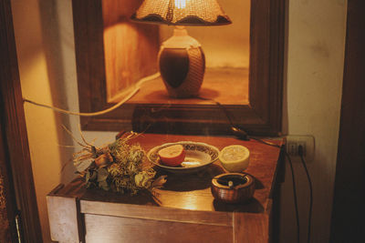 High angle view of citrus fruit on table by illuminated lamp at home