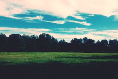 Scenic view of grassy field against cloudy sky