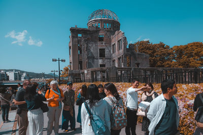 Group of people in front of building against sky