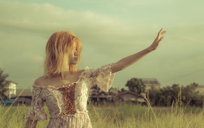 Woman standing on field against sky