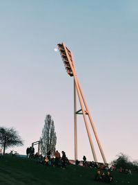 People in traditional windmill against clear sky