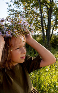 Child with a wreath on his head. girl in a dress and a straw hat.wellness and freedom concept.