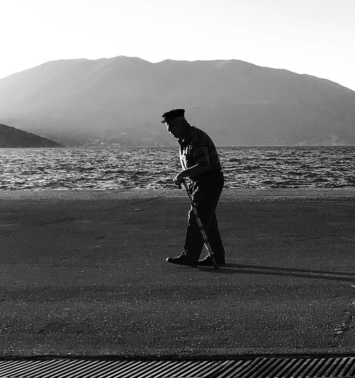 MAN STANDING ON BEACH AGAINST SKY