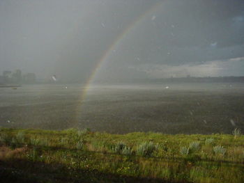 Scenic view of field against sky during rainy season