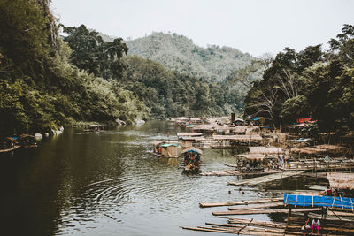 High angle view of boats on river amidst trees against sky