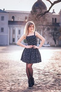 Portrait of young woman standing on walkway