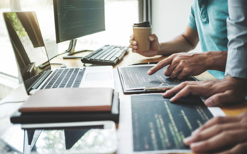 Midsection of man using laptop on table
