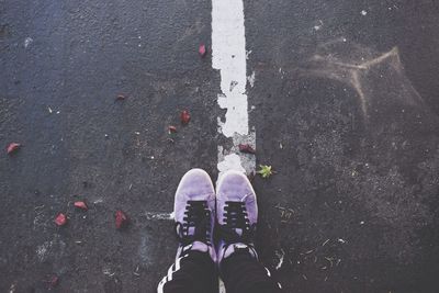 Low section of man standing on road