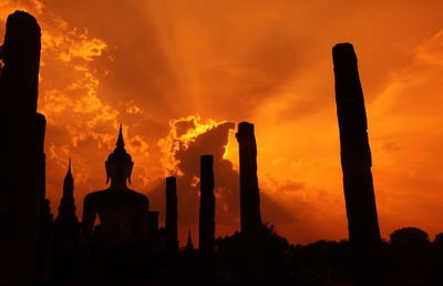 Silhouette statue against sky during sunset