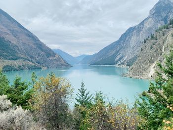 Scenic view of lake by mountains against sky