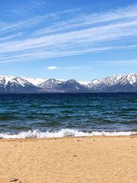 Scenic view of sea and mountains against sky