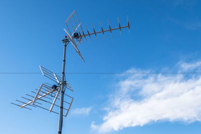 Low angle view of telephone pole against blue sky