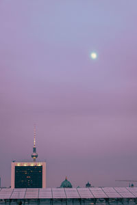 Low angle view of communications tower against sky at dusk