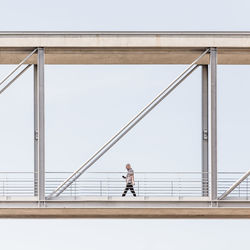 Man on bridge against clear sky