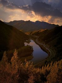 Scenic view of lake and mountains against sky during sunset