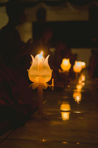 Close-up of lit candles on wall