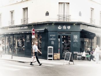 People walking on street against building in city