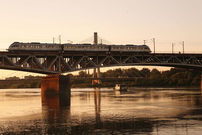 Train on srednicowy bridge over river against sky