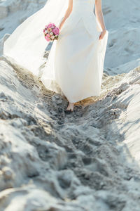 Low section of woman standing on beach