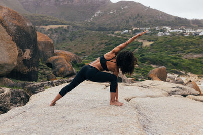 Side view of woman sitting on rock