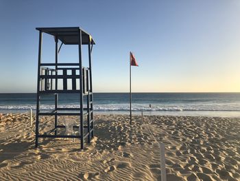 Lifeguard hut on beach against clear sky