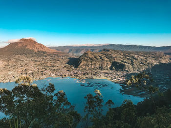 Scenic view of sea and mountains against blue sky