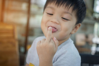 Boy sticking out tongue while showing middle finger