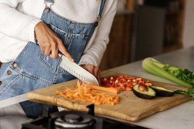 Midsection of woman preparing food on cutting board