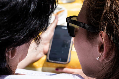 Close-up portrait of young woman using mobile phone