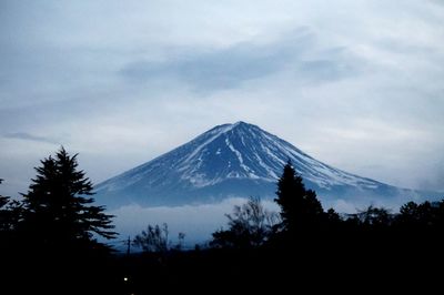 Scenic view of snowcapped mountain against cloudy sky