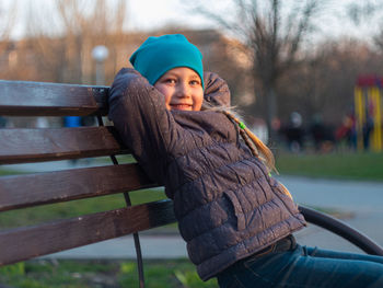 Happy girl with long hair portrait in spring park on tree sunset outdoor. family leisure on open air