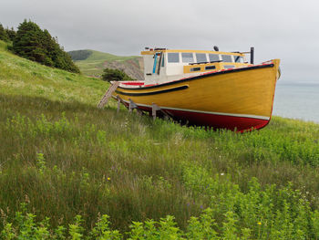 Boat moored on land against sky