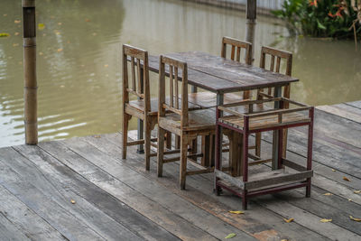 Empty chairs and table by lake