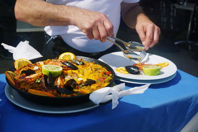 Midsection of man eating food at table