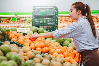 Full length of woman and vegetables in market