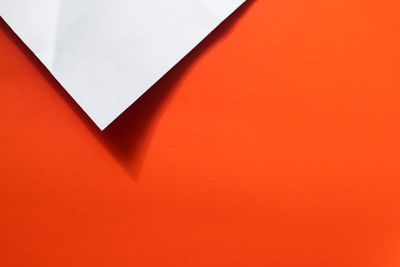 High angle view of empty paper against orange wall