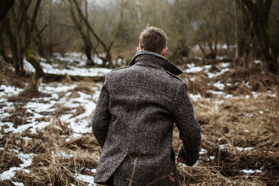 Rear view of man walking in forest