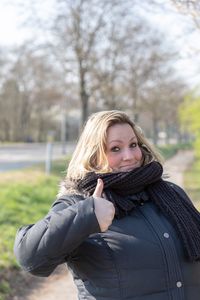 Portrait of woman gesturing against trees