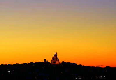 Silhouette of buildings against sky during sunset