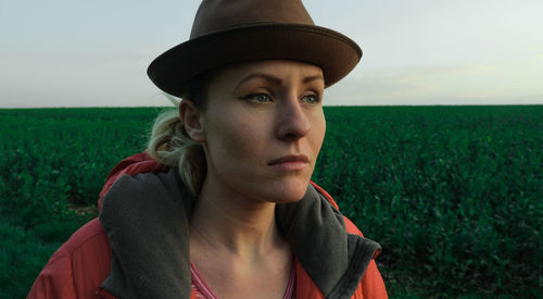 Panoramic view of young woman looking away on field