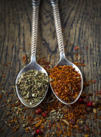 Close-up of seasoning in spoons on wooden cutting board