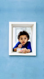 High angle view of girl sitting on wall