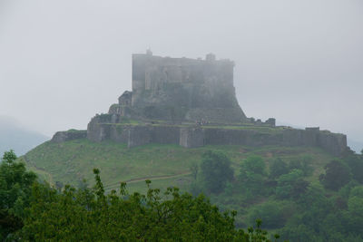 Castle on mountain against sky