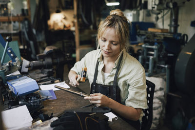 Female craftsperson making jewelry at workshop