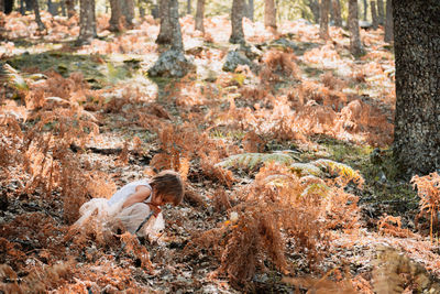 Full length of cute girl crouching in forest