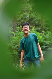 Full length of man smiling while sitting on land
